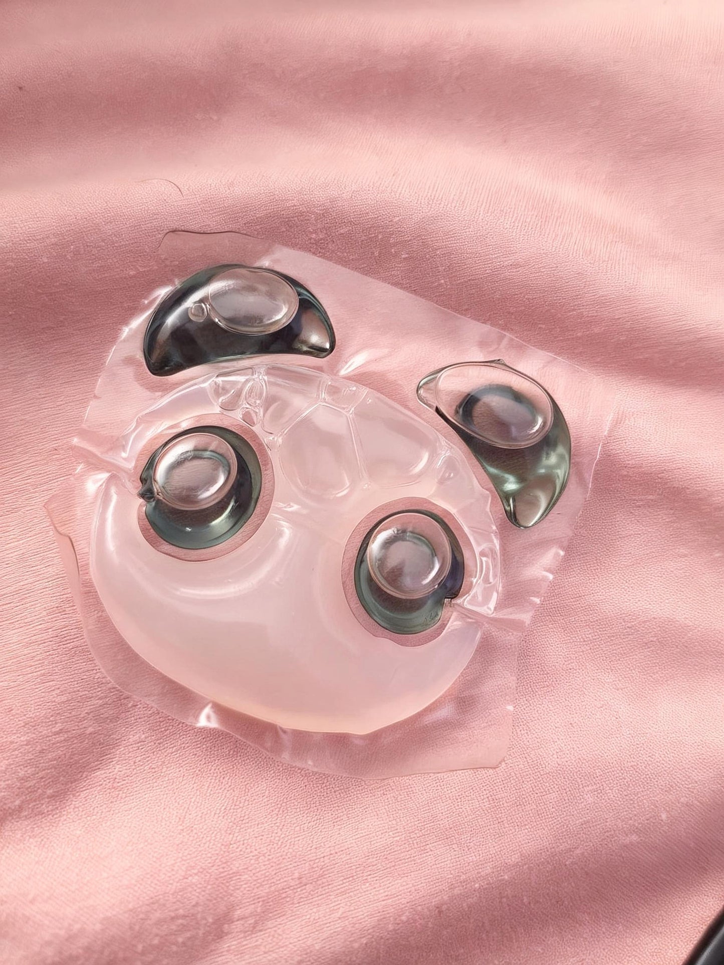 Single Panda Pod laundry pod with black ears and eyes resting on pink fabric