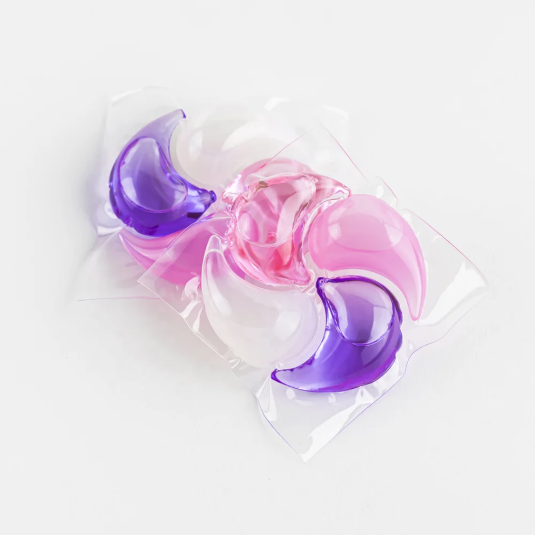 Four loose Swirl Pod laundry pods in Sakura Blossom with pink, purple and white chambers